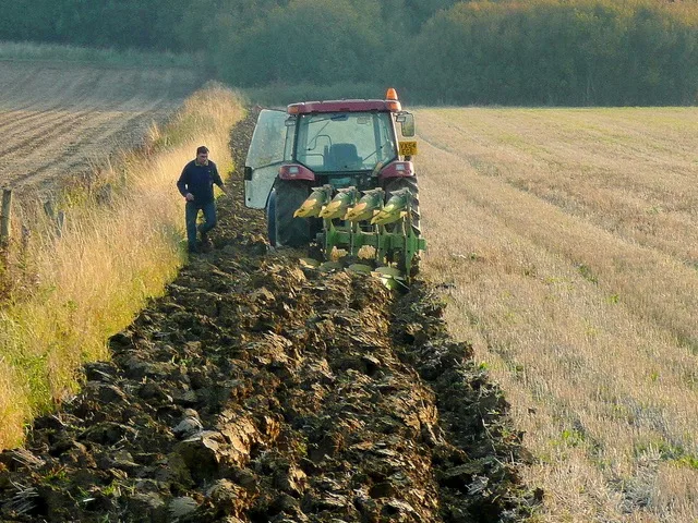 Mezőgazdasági munkás traktorral talajmunkát végez a szántóföldön